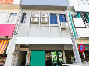 un edificio con una puerta y ventanas azules en OYO 89950 365 Nice Stay en Miri