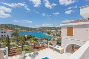 Haus mit Balkon und Blick auf das Wasser in der Unterkunft Villa Elena in Sevid