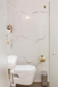 Baño blanco con aseo y lavamanos en AGORA luxury BOUTIQUE HOTEL en Loutraki