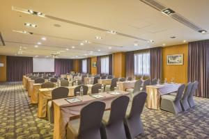 a conference room with tables and chairs and a screen at Fuji Grand Hotel in Xizhi