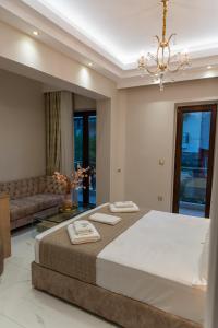um quarto com uma cama grande e um sofá em AGORA luxury BOUTIQUE HOTEL em Loutraki