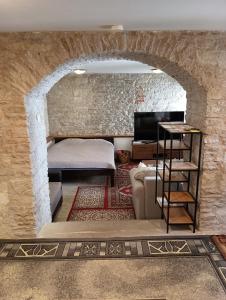 een kamer met een bakstenen muur, een bed en een bank bij Kauba 6a apartment in Kuressaare
