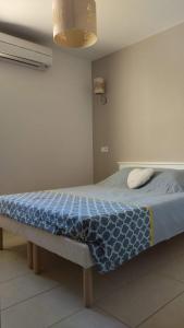 una camera da letto con un letto con una coperta blu di Maison duplex 2 chambres, avec jardin, 800m plage a Belgodère