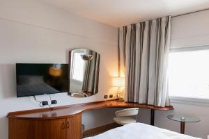 a bedroom with a desk and a mirror and a bed at Belstay Milano Assago in Assago