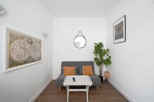 een woonkamer met een bank en een tafel bij Studio chez Thomas in Parijs