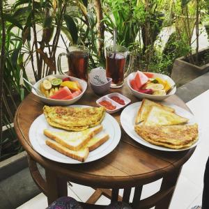 a table with plates of food and bowls of fruit at Sudiana House in Ubud +44 photos