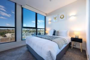 Tempat tidur dalam kamar di Mega Style Apartments Flinders St