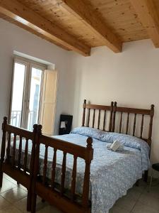 une chambre avec un lit en bois et une fenêtre dans l'établissement la casa dei ricordi, à Castelluccio Superiore