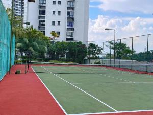 a tennis court with a tennis net and a building at Vesta Homes, Danga Bay Baypoint with Seaview, Johor Bahru in Johor Bahru