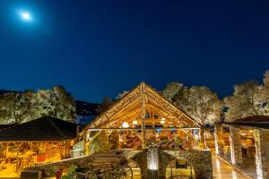 un edificio de madera por la noche con la luna en el cielo en Porto Koundouros Beach and Villas, en Koundouros