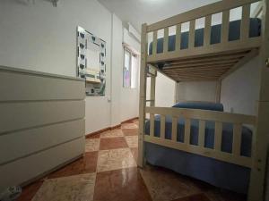 um quarto com 2 beliches e um corredor em Espectacular apartamento junto al mar em Chipiona