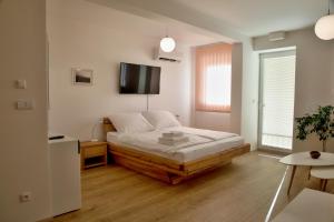a bedroom with a bed and a flat screen tv at Mikulov Apartments - Apartmán Radka in Mikulov