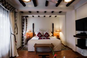 sypialnia z dużym białym łóżkiem i telewizorem w obiekcie The Dwarika's Hotel w Katmandu