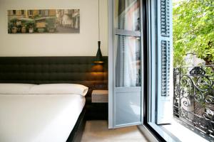 a bedroom with a bed next to a window at Woohoo Rooms Chueca in Madrid