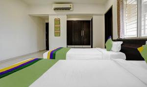 Habitación de hotel con 2 camas y ventana en Treebo Trend Excellent Homes, Nashik, en Nashik