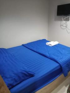 Una cama azul con una toalla blanca encima. en Ban Por Fai, en Cha Am