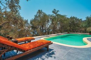 a swimming pool with a bench and a table at Villa zeytin patara On the Lycian walking path in Kas