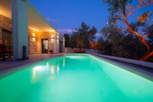 a swimming pool in front of a house at night at Villa zeytin patara On the Lycian walking path in Kas +3 photos