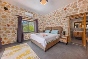 a bedroom with a bed and a stone wall at Villa zeytin patara On the Lycian walking path in Kas