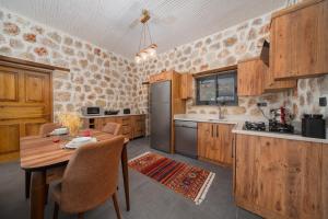 a kitchen with wooden cabinets and a wooden table with a tableablish at Villa zeytin patara On the Lycian walking path in Kas