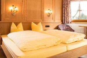 sypialnia z dwoma łóżkami i żółtymi poduszkami w obiekcie Appartement Paulis Hof w mieście Ischgl