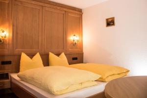 sypialnia z łóżkiem z żółtymi poduszkami w obiekcie Appartement Paulis Hof w mieście Ischgl