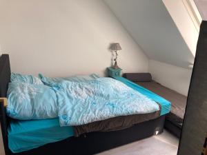 uma cama com um edredão azul num quarto em SchöneWohnung mit eigenem Gsrten und Eingang em Schwentinental