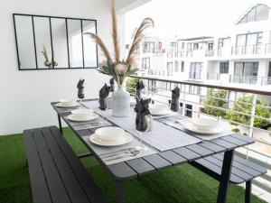 a table on a balcony with a view of a building at Azure 213-Luxury 2 Bedroom Apartment with an Inverter & Battery Backup Power in Big Bay