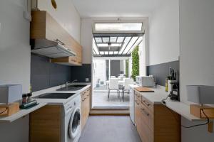 a kitchen with a washer and dryer in it at Studio chez Thomas in Paris