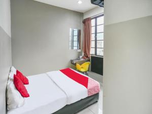 1 dormitorio con cama blanca y almohadas rojas en OYO 89950 365 Nice Stay en Miri