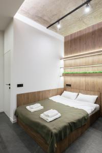 a bedroom with a bed with two towels on it at Luxury Apartments Smart House in Uzhhorod