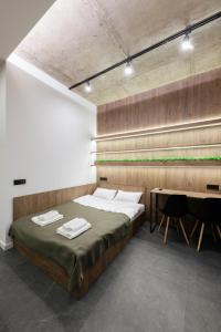 ein Schlafzimmer mit einem großen Bett und einem Schreibtisch in der Unterkunft Luxury Apartments Smart House in Uschhorod