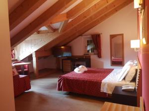 a bedroom with a bed with a red comforter at Albergo Cavallino Bianco in Rumo