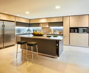a kitchen with stainless steel appliances and a counter with stools at Nico Apartasuites in Bogotá