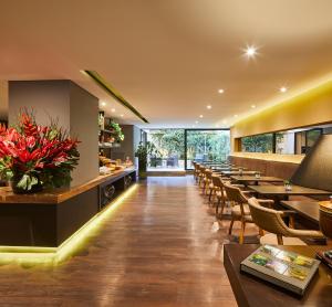 a restaurant with tables and chairs and a bar at Nico Apartasuites in Bogotá