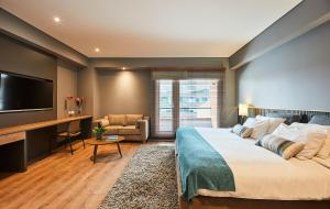 a hotel room with a large bed and a desk at Nico Apartasuites in Bogotá