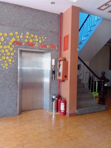 ascensor en un edificio con escalera y puerta en KHÁCH SẠN ĐẾ VƯƠNG, en Cao Lãnh