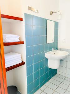Baño de azulejos azules con lavabo y espejo en Le Domaine d'Arignac en Arignac