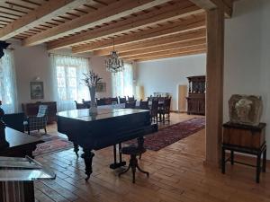 a room with a piano and a dining room with chairs at Tarcal Apartman in Tarcal