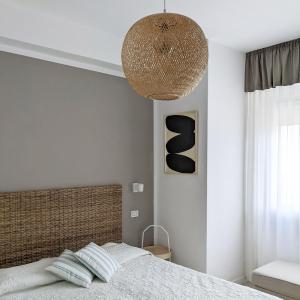 a bedroom with a bed with a large light fixture at Hotel Piccolo Mondo in Lido di Camaiore
