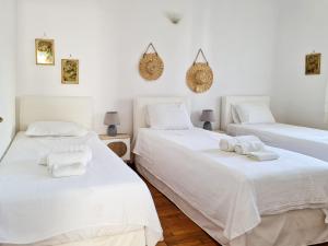 three beds in a room with white walls at My Home in Naxos in Naxos Chora