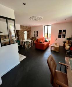 una sala de estar con un sofá y una mesa en La bâtisse de Manel, en Cholet