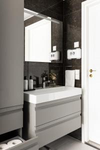 Un baño con un lavabo blanco y un espejo. en Luxury Skyscraper Apartment with Amazing view over Helsinki, en Helsinki