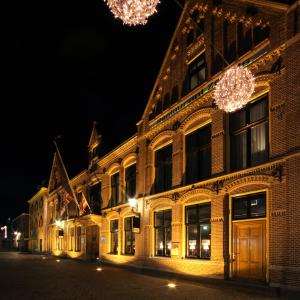 a building with lights on the side of it at night at Grand Hotel Alkmaar in Alkmaar