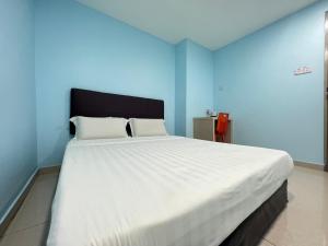 a large white bed in a blue room at OYO 90789 Stutong Point in Kuching
