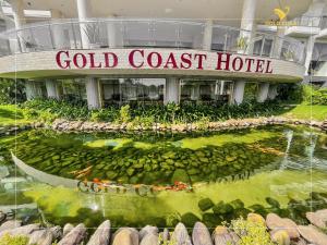 a building with a pond in front of a hotel at Gold Coast Hotel Resort & Spa in Dong Hoi