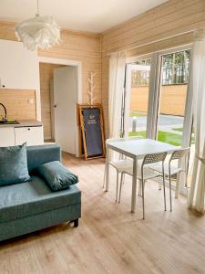 a living room with a couch and a table with chairs at Seaside Harmony in Pogorzelica