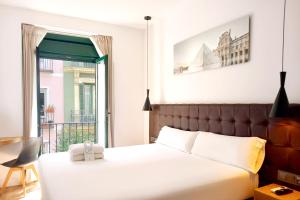 - une chambre avec un grand lit et un balcon dans l'établissement Woohoo Rooms Fuencarral, à Madrid