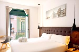 a bedroom with a large bed and a balcony at Woohoo Rooms Fuencarral in Madrid