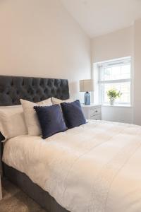 a bedroom with a large bed with blue pillows at Apartment in the Countryside with Hot Tub in Trowbridge